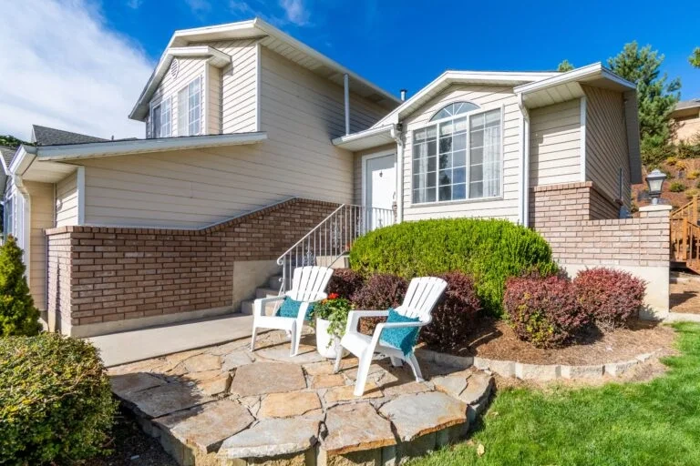 A modren house  side view and two chairs in the  lawn
